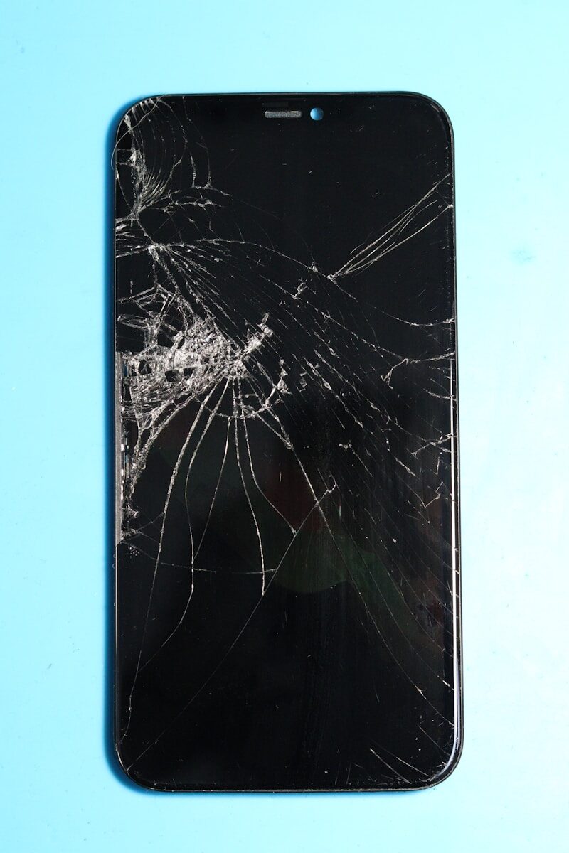 Broken smartphone screen on a blue surface